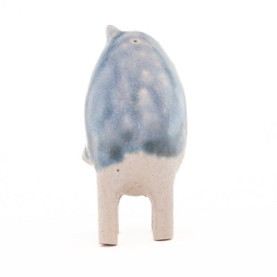 Ceramic sculpture of a small blue and white creature with small ears and eyes and no arms but 4 legs.