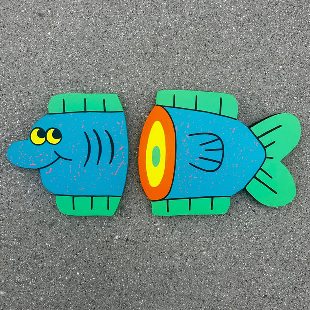 2 die cut wooden panels, one painted and cut to resemble a blue cartoon fish head. The other, painted and cut to resemble a cartoon fish tail.
