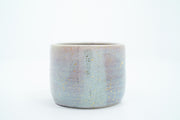Short ceramic bowl with a light blue and light purple multicolor glaze and golden splatters.