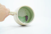 Inside view of ceramic mug with mint green inside and gold speckles.
