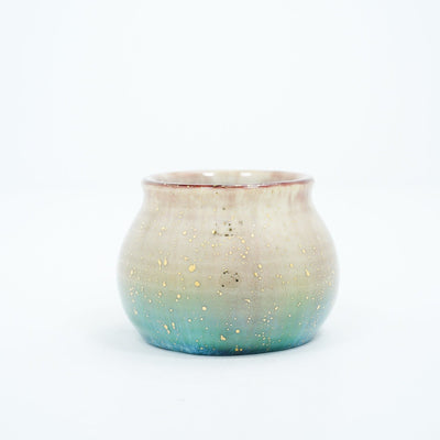 Small ceramic pot with a gradient of light brown to blue and gold speckles.