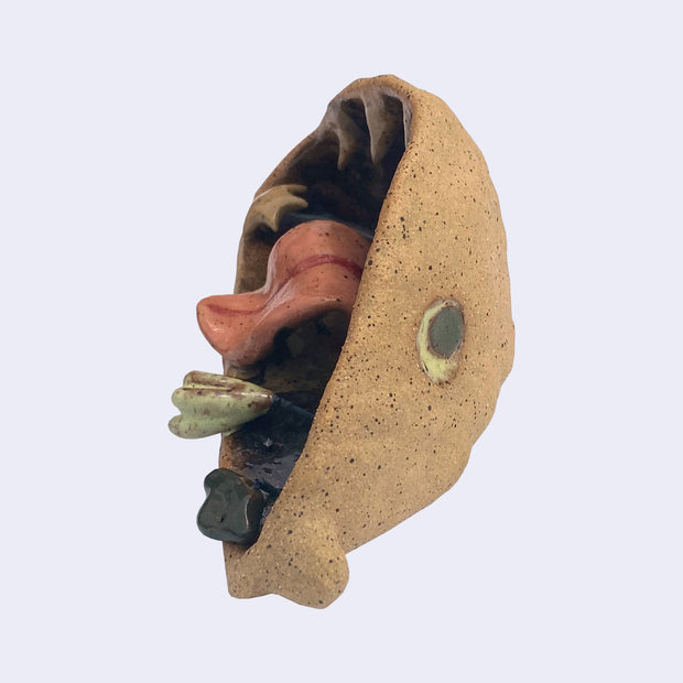 Ceramic sculpture of the interior of a monster's mouth, made to look like an underwater cave. It has a pink tongue and teeth that look like stalactites.