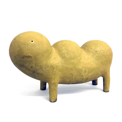 Ceramic sculpture of a dark yellow creature, standing on 4 legs with a body shaped like a loaf of lumpy bread.