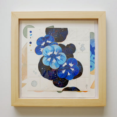 Framed collage style artwork, of a stylistic flower and leaf composition. The flowers are blue and the leaves are a dark galaxy pattern, with a small character doodled nearby. Below the top artwork is a mostly covered paper containing painted shapes, likely of plant life.