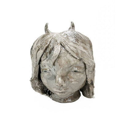 Gray sculpture of a girl with short hair and small devil horns.