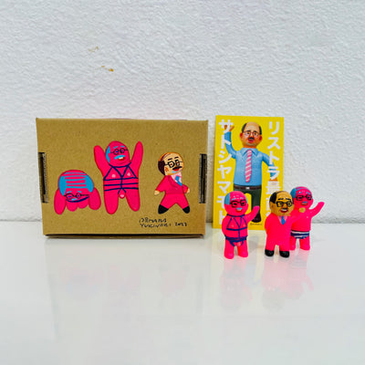 Set of 3 small vinyl hot pink figures of little business men. One wears a suit, another wears a red bondage wear and the last wears striped underwear. They stand next to a painted box.
