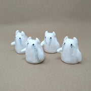 4 small white ceramic ghosts with little devil horns, all crying watercolor tears. They have no facial features other than black eyes and minimal body features, only one arm that extends outwards.