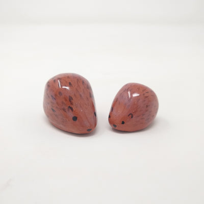2 small, simplistic rounded sculptures of brown hedgehogs.
