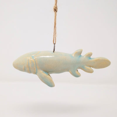 Ceramic ornament shaped like a fish, without any facial features.