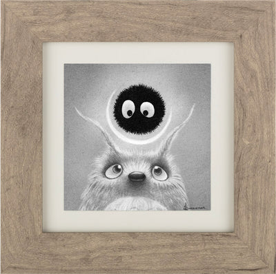 Small greyscale graphite drawing of a Totoro, with skinny long ears and shiny realistic eyes. It looks up towards a round black soot sprite, which returns its gaze. Piece is in a thick wooden frame.