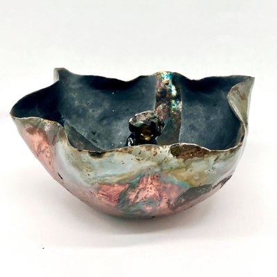 Multicolor ceramic bowl with wavy shaped body and a small character in the center.