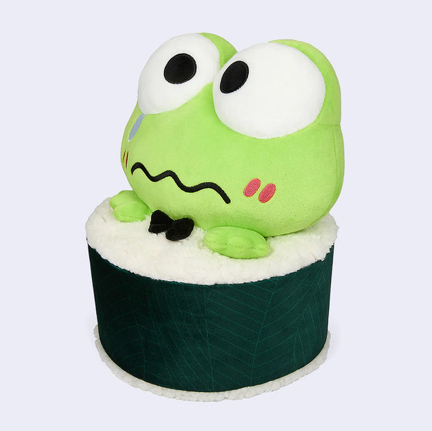 Plush doll of Sanrio's Keroppi, a cute green frog, with large eyes and a worried expression. He's inside a sushi roll, with just his head and small hands popping out. He sheds a single tear and wears a black bowtie.