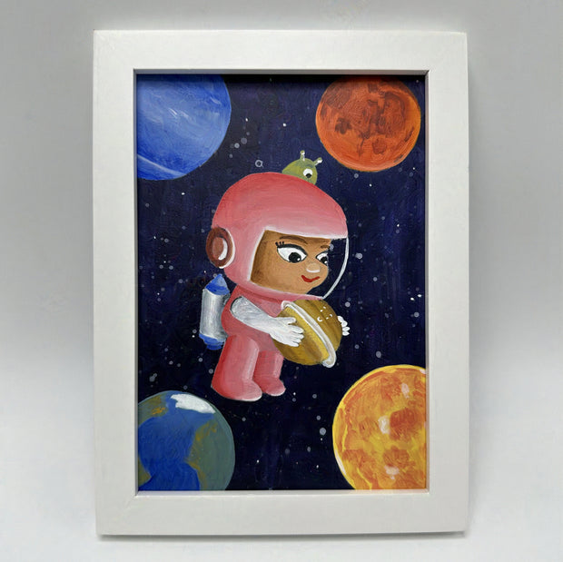 Illustration of a small, cute tan girl in a pink space suit, holding a small smiling planet in her arms. She floats in space with colorful planets framing her, and a small green alien sitting atop her head. Framed in a thick white frame.