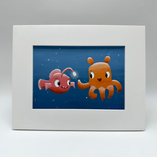 Painting of a vampire squid and an angler fish, done in a cute cartoon style with large eyes and smiling faces. They reach hands out to each other, as though high-fiving. Piece is in thick white frame. 