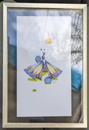 Drawing on white paper of a woman sitting on a log, facing away. She has large butterfly wings, patterned and colored yellow, blue and pink. She holds a large blueberry and looks towards it, with a blueberry resting behind her. Piece is in a gold frame with a glass backing.
