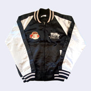 Shiny polyester bomber jacket with black body and white sleeves. Front has 2 small embroidered graphics on the chest, right side is text that reads "Milky, the nature goodness of milk from us to you" and the other side is an embroidery of Peko Chan's face.