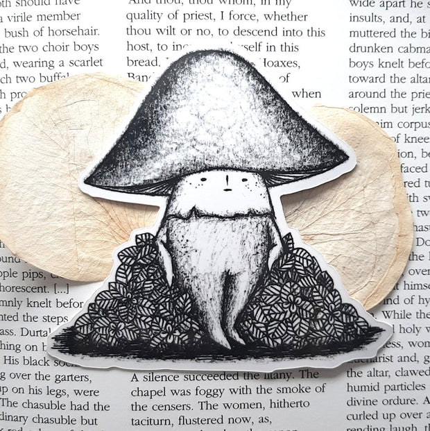 Black and white sticker of a mushroom with a small cartoon face standing and resting on a bush.
