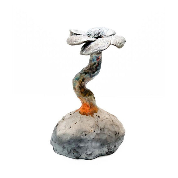 Ceramic sculpture of a thick stemmed flower, rising up from a rock.