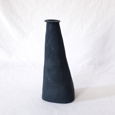 Black vase without curvature, angled in like a triangle. Top is a small opening.