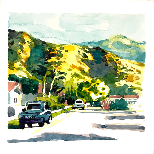 Plein air painting of a neighborhood street right up against large brown hills, speckled with greenery. 