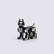 Wooden dog made of many geometric shapes, standing on its legs. It is painted black with white bone detailings.