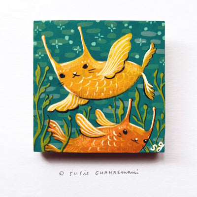 Painting of 2 fish, one yellow and one orange, both with cat faces. They swim over one another against a teal background with kelp.