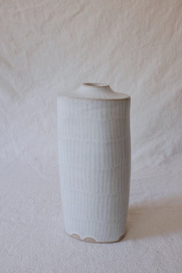 Ceramic vase with small opening and very faint gray lines.