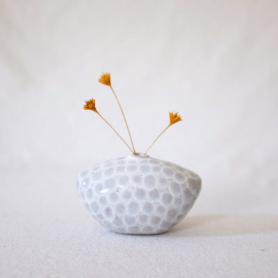 Small white vase with wide edges and faint gray dots.