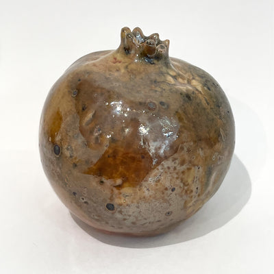 Brown ceramic sculpture of a pomegranate. 