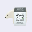 Small off white planter with a semi flat polar hear head coming out of one side. It is wrapped in product packaging, which shows what plant seeds are included. (Wild Strawberry)