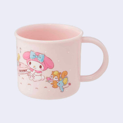 Short pink cup with a mug handle featuring a vintage style illustration of Sanrio's My Melody, sitting and playing a small piano. She is surrounded by cute, small animals such as a mouse, squirrel and bird.