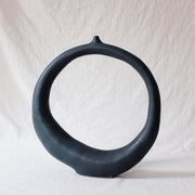 Dark navy blue vase shaped like a circle.
