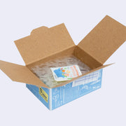 Open box of miniature stickers, made to resemble a shipping box with bubble wrap around the product and a small invoice. Exterior of box looks like realistic office supply box.