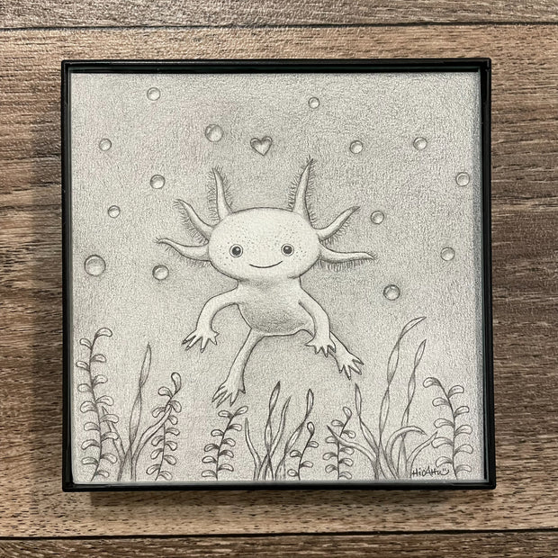 Graphite drawing of an axolotl, floating in water with bubbles and a heart shaped bubble directly above it. Sea weed frames the bottom of the piece. 