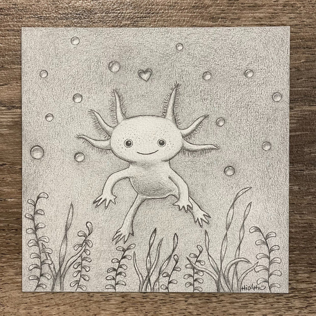 Graphite drawing of an axolotl, floating in water with bubbles and a heart shaped bubble directly above it. Sea weed frames the bottom of the piece.
