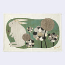 Illustration on a beige tea towel of a rabbit with flowers on a textured background