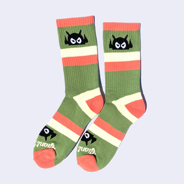 Striped salmon pink, green and cream socks with a black cartoon robot head on them and salmon colored heels and toes. The robot head decorates the cuff end of each sock so that it peeks out when you wear sneakers.