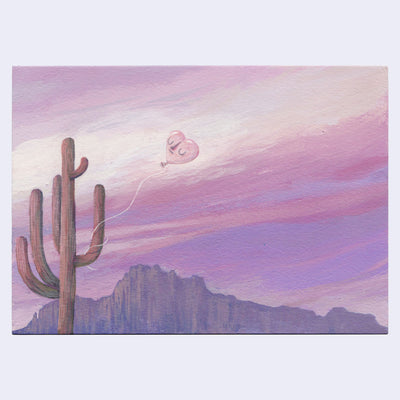 Painting of a pink and purple sunset desert landscape. A heart shaped balloon is tied to a large Saguaro cactus.