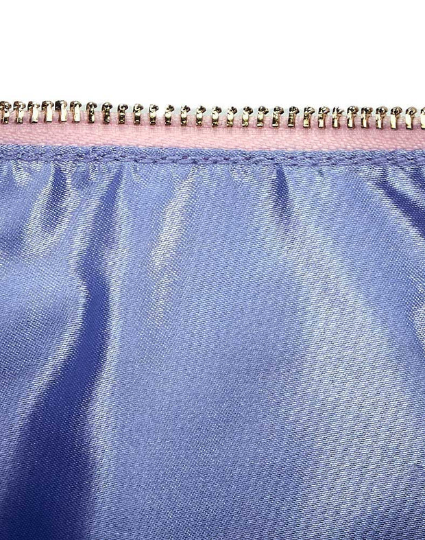 Inner lining of bag, featuring a lavender satin material, pink fabric lining a gold tone zipper.