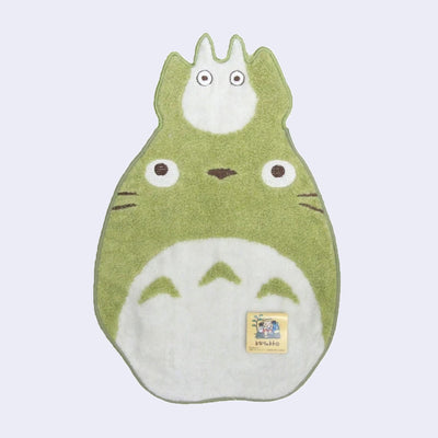 Lightweight die cut green towel featuring Chibi Totoro and a smaller white Totoro creature stacked atop its head. 
