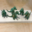 Set of green dinosaur figurines on a wooden surface