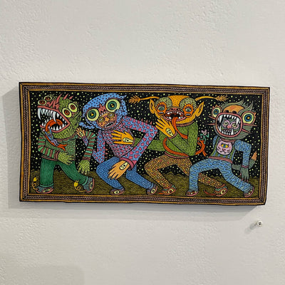 Illustration on wood of 2 colorful goblins with patterned outfits and two humans inside of goblin costumes walking with arms linked all together. 
