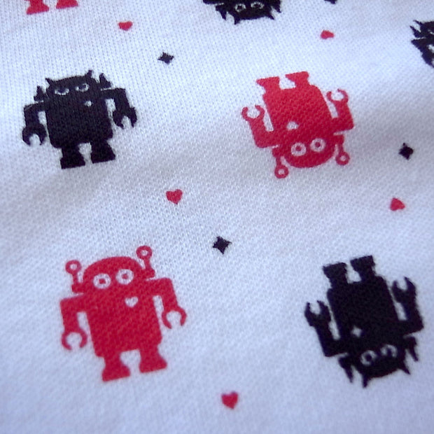 Close up of cute cartoon robot pattern on baby onesie. Black robot has angry eyes. Red robot has round eyes and a heart emblem on its chest.