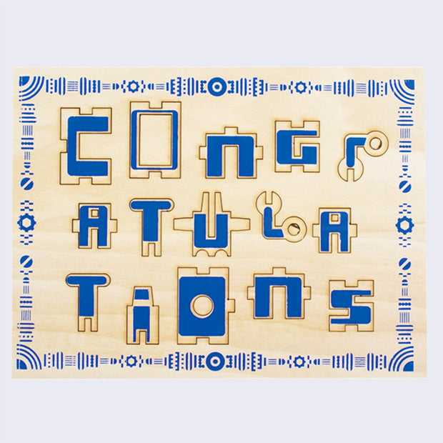 Wooden sheet with pop out puzzle piece elements. The elements spell out "Congratulations"