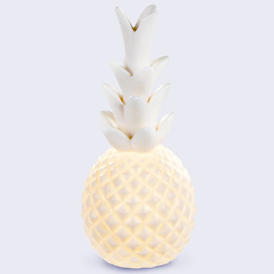 Lamp made to look like a pineapple, with a rounded body with a quilted pattern and a stem of leaves atop.