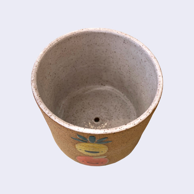 Overhead view of a ceramic planter, displaying a drainage hole.