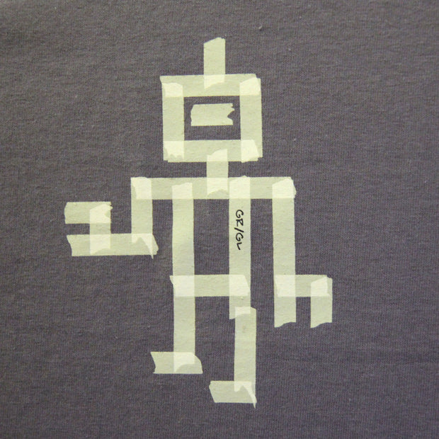 Close up of robot illustration made up of light green tape. The torn ends of the tape make it look realistic and not printed on.