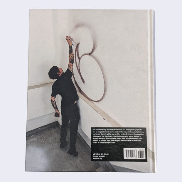 Back cover of the book features a young man spray painting a big letter C.