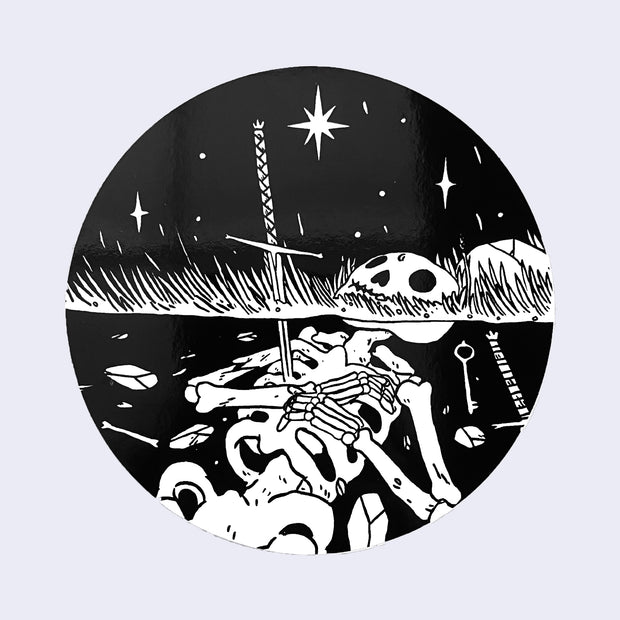Black circle sticker with a drawing of a skeleton half buried under a grassy area. The scenery is peaceful with stars in the sky.