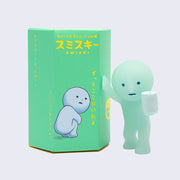 Simplified light teal character with a solemn expression, with one hand propped onto its blind box packaging next to it, while holding a roll of toilet paper in its other hand.